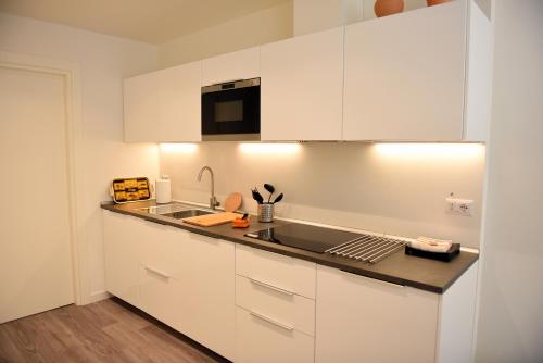 a kitchen with white cabinets and a sink at Le Rondinelle in Como