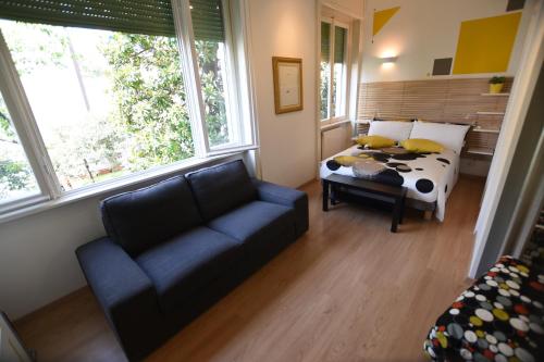 a living room with a bed and a couch and a window at Le Rondinelle in Como