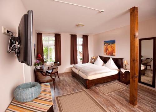 a living room with a bed and a tv at Hotel Bess in Albersdorf