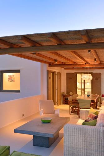a living room with a couch and a table at Villa Castalia by Thalassa Residence Mykonos in Elia Beach