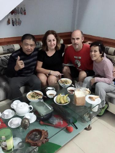 a group of people sitting on a couch eating food at Thanh Thúy Guesthouse in Ðông Hà