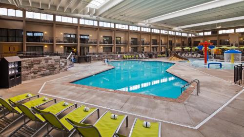 uma grande piscina num edifício com cadeiras em frente em Best Western Plus Bloomington Hotel em Bloomington