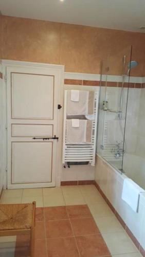 La salle de bains est pourvue d'une douche et d'une porte blanche. dans l'établissement Château de La Sémondière, à Brécey