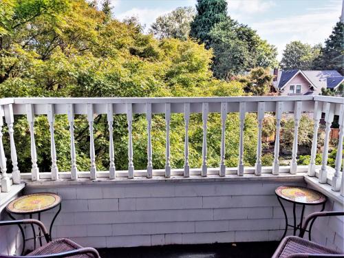 a white railing on a porch with chairs at Evermore Guesthouse in Portland