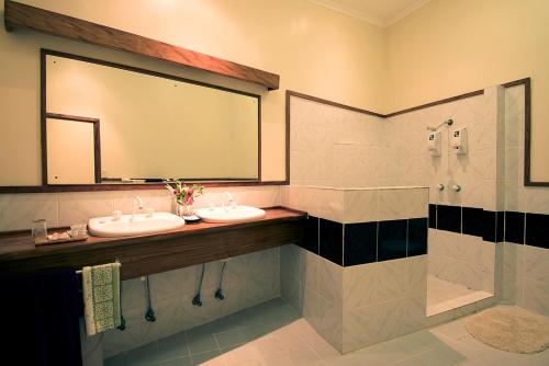 ein Badezimmer mit zwei Waschbecken und einem großen Spiegel in der Unterkunft Tawali Leisure & Dive Resort in Alotau