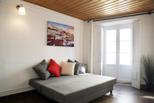 ein Zimmer mit einem Bett mit Kissen darauf in der Unterkunft Chiado/Carmo Apartment in Lissabon