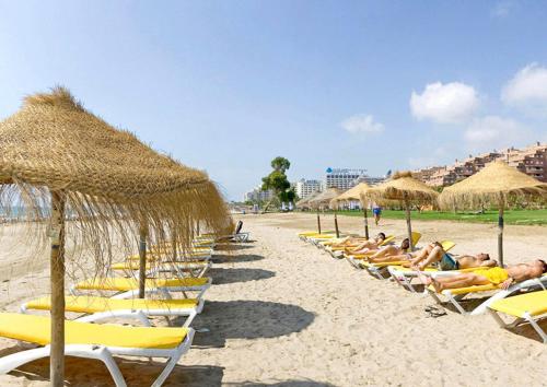 オロペサ・デル・マールにあるApartamento en Primera Línea de Playa en Marina d'Or Magic World con Ubicación Privilegiada - Felixの浜辺の椅子・藁傘