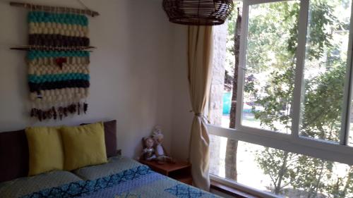 1 dormitorio con cama y ventana grande en Conjunto Payllahue, en Pucón