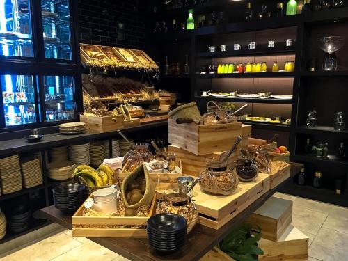 a restaurant with a counter with plates and food at Sofitel Wellington in Wellington