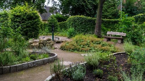 a park with a bench in a garden at Ostel Jugendhotel Bremervörde in Bremervörde