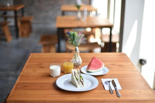 a wooden table with two plates of food on it at Mogens Guesthouse in Bandung
