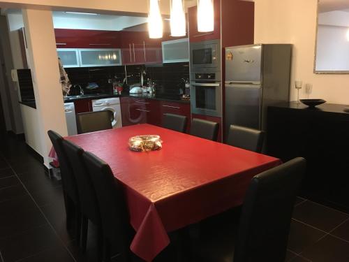 a kitchen with a red table with chairs and a refrigerator at Praia de Mira in Praia de Mira