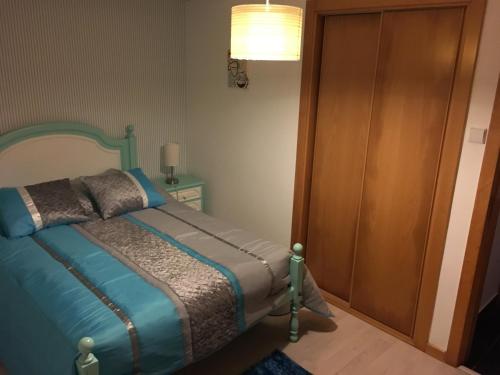 a bedroom with a bed next to a wooden door at Praia de Mira in Praia de Mira