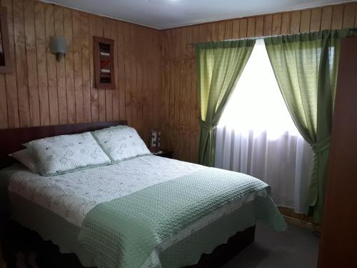 a bedroom with a bed and a window at Agroturismo los Colihues 2 in Castro