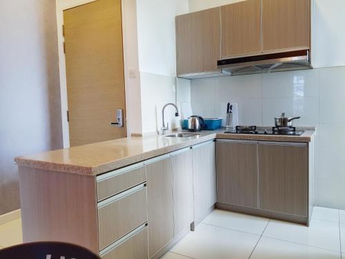 a kitchen with wooden cabinets and a counter top at No.2 The Loft @Puchong Skypod Residence in Puchong