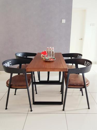 a wooden table with chairs and a plate on it at No.2 The Loft @Puchong Skypod Residence in Puchong