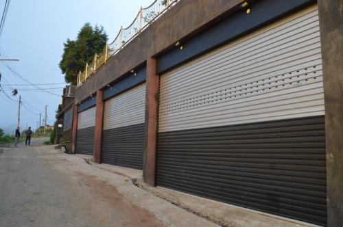 a row of metal garage doors on the side of a building at Misty Paradise of Lake Gregory in Nuwara Eliya