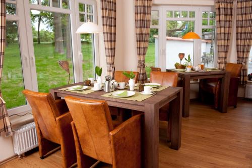 a dining room with two tables and chairs and windows at Hotel Bess in Albersdorf