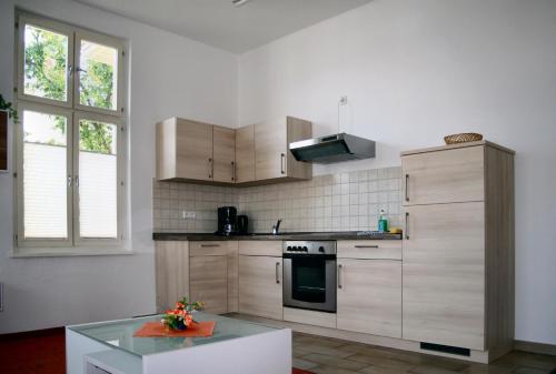 a kitchen with wooden cabinets and a stove at Ferienwohnung Villa Dora, Seebad Ahlbeck in Ahlbeck