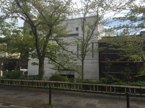 a white building with trees in front of it at Luxury Condo Shikine An Gion Shirakawa in Kyoto