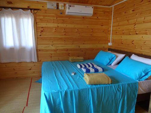 a blue bed in a room with wooden walls at Agonda Paradise in Agonda