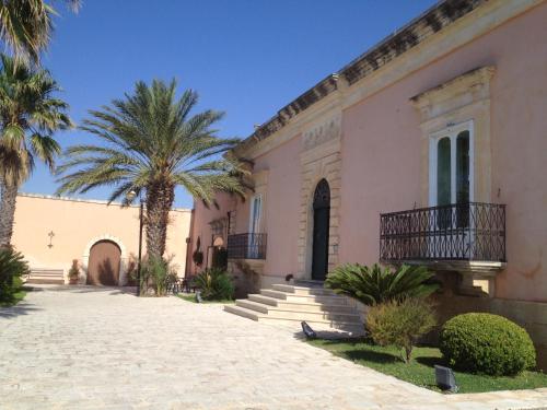a building with a palm tree in front of it at Villa Principe Di Belmonte in Ispica
