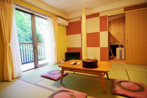 a living room with a table and a large window at Misenkan in Tenkawa