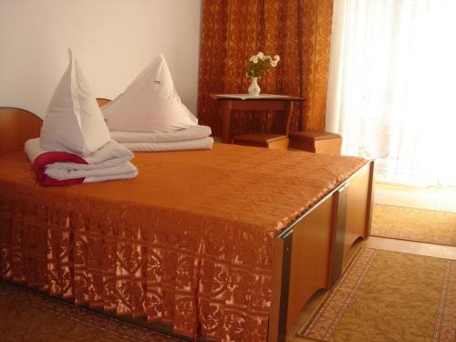 ein Bett mit weißen Kissen darüber in der Unterkunft Motel Cristina in Bicaz