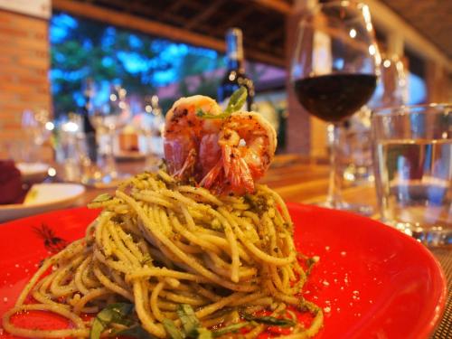 a red plate of spaghetti with shrimp on top at Hula Hula Seafront Phu Quoc in Phu Quoc