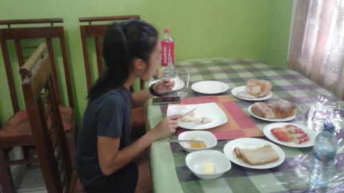 Una donna seduta a tavola che mangia. di Mathews Holiday Resort a Habarana