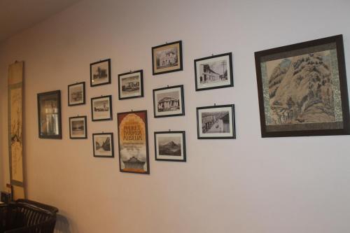 a wall with a bunch of pictures on it at Ming Shou Boutique House in Phuket Town