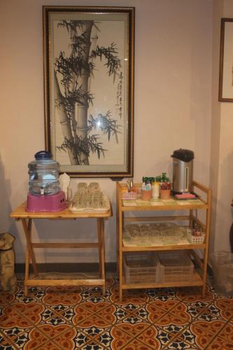 a room with two tables and a picture on the wall at Ming Shou Boutique House in Phuket Town