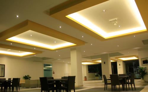 a dining room with tables and chairs and lights at H2H - Reunion House @ Majestic Ipoh 家好月圆 in Ipoh