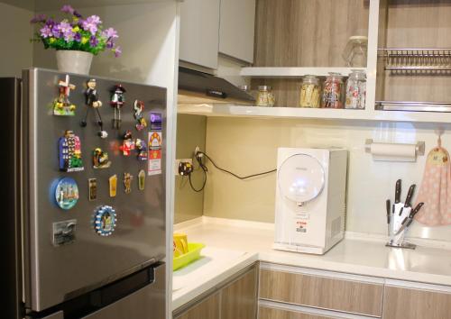 a kitchen with a refrigerator with magnets on it at H2H - Reunion House @ Majestic Ipoh 家好月圆 in Ipoh