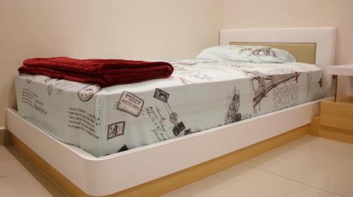 a white bed with a red blanket on it at H2H - Reunion House @ Majestic Ipoh 家好月圆 in Ipoh