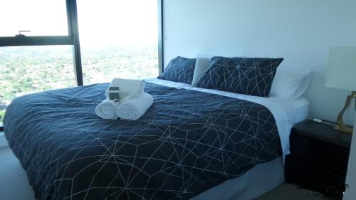 a bedroom with a bed with two speakers on it at Whitehorse Towers Self Service Holiday Apartment in Box Hill