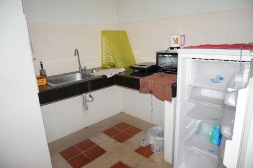 a small kitchen with a sink and a refrigerator at Kao karat in Pattaya