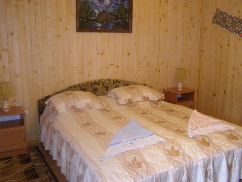 1 dormitorio con 1 cama grande y 2 mesas en uoksany en Karpaty