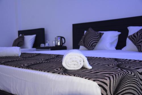 a bed with a towel laying on top of it at Trinco Lagoon in Trincomalee
