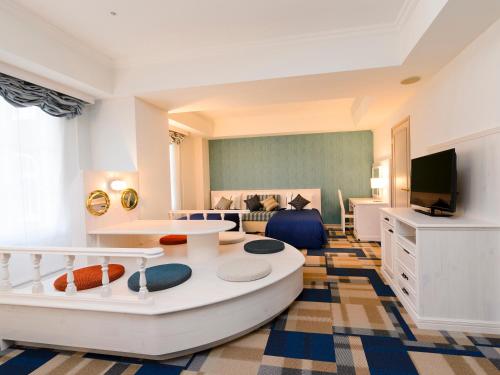un ampio soggiorno con divano e TV di Hotel Denhaag Huis Ten Bosch a Sasebo