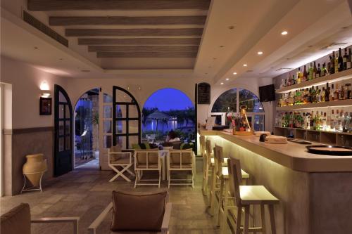 a bar in a restaurant with a view of the water at Kalypso Hotel in Naousa