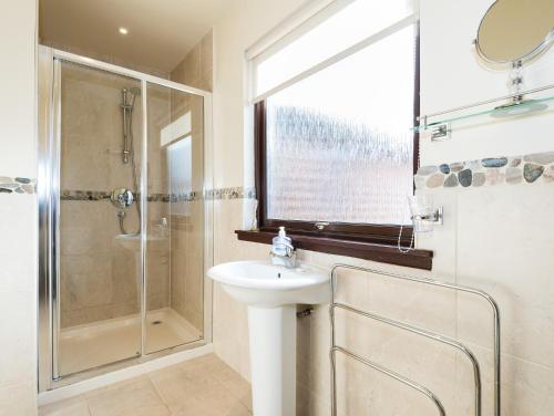 ein Bad mit einem Waschbecken und einer Dusche in der Unterkunft Lodge 9 Glengoulandie Lodges in Aberfeldy