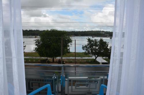 a window with a view of a river and trees at Trinco Lagoon in Trincomalee