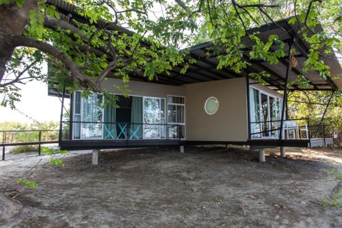 a house with a tree in front of it at Zambezi Mubala Lodge in Katima Mulilo
