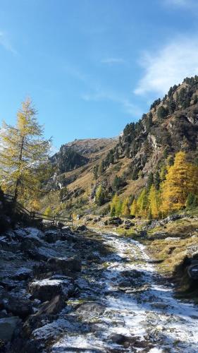 a river with snow on the side of a mountain at Adlerhof in Sankt Leonhard im Pitztal