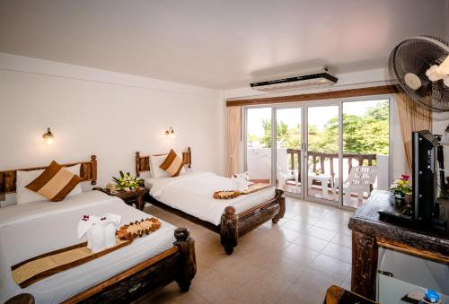 a bedroom with two beds and a balcony at Aonang Sunset Hotel - SHA Extra Plus in Ao Nang Beach