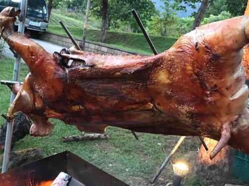 a large turkey being cooked on a grill at Goose House in Yung-an-ts'un