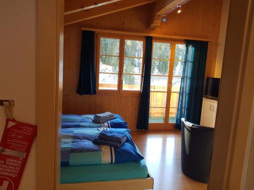 una camera con due letti in una stanza con finestre di Oeystrasse 10a ad Adelboden