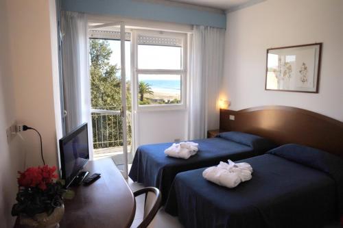 a hotel room with two beds and a window at Villa Dei Principi Hotel in Terracina