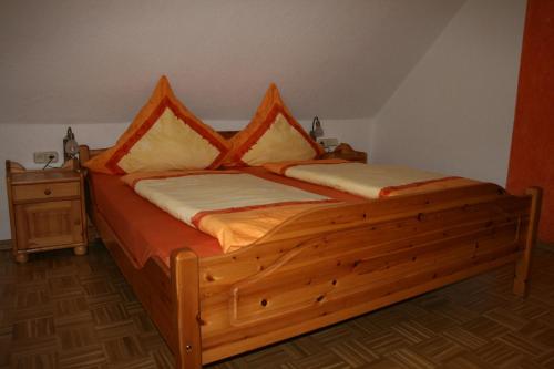 a wooden bed with two pillows on top of it at Weingut & Gästehaus Stephan Kohl in Neumagen-Dhron